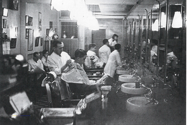 BYGONE BARBERS: This shot of the interior of Jack Honore’s Barbershop, which opened on Nassau Street around 1913, is among the 90 bringing the town’s past to life in the show currently on view at the Historical Society of Princeton’s two locations.      (Photo courtesy of Historical Society of Princeton)