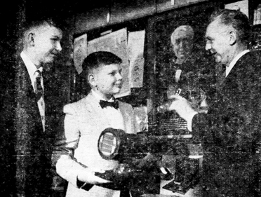 VINTAGE TOWN TOPICS: This photograph appeared in Town Topics in 1955 under the headline “From Edison to Color Television.” It shows John Madey, 11, (center) with his older brother Julius, and Howard E. Schrader, then Princeton University’s official photographer, whose vacuum tube collection was on display in Princeton University’s Firestone Memorial Library. Mr. Schrader is holding an original R.C.A. color television tube, while John, in front of a portrait of Thomas Edison, holds an original Lawrence Color Tube. John Madey received a clipping with the photograph from Mr. Schrader’s niece Mary Johnson, who came across it when she was preparing a history of her family.