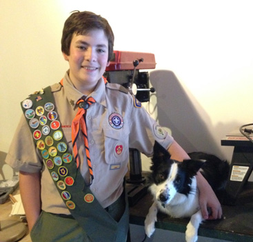 AWARD WINNER: Tag Quijano with his border collie Sadie in his home basement workshop where he has built his own 3D printer among other innovative projects. The keen scout, along with two other Princeton Day School (PDS) students, won a 2014 Sustainable Princeton Leadership Award last week. Tag designed and led the construction of a Human Powered Rain Water Delivery System for the teaching garden at PDS that he hopes will be a model for others interested in conservation.(Photo by Jill Carpe)