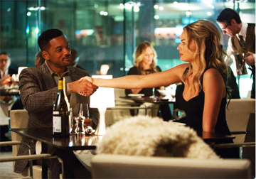 CONGRATULATIONS! YOU HAVE PROVEN TO BE AN EXCELLENT STUDENT: Nicky Spurgeon (Will Smith, left) celebrates Jess Barrett’s (Margot Robbie) on being such a quick learner. Nicky took her on as his student after she botched an attempt to rob him by having her “husband” discovering them together in her hotel room.(© 2015-Warner Bros. Entertainment Inc.)