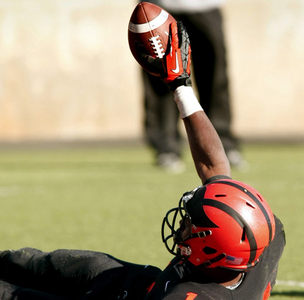 #14 holds up the ball in the end zone after scoring a 2nd quarter TD